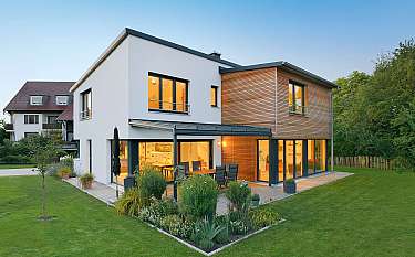 Modernes Einfamilienhaus mit Holzfassade, Terrasse und gepflegtem Garten